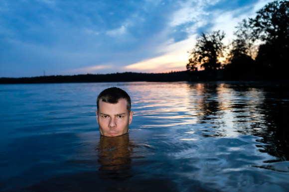 Man in water swimming late at night photo