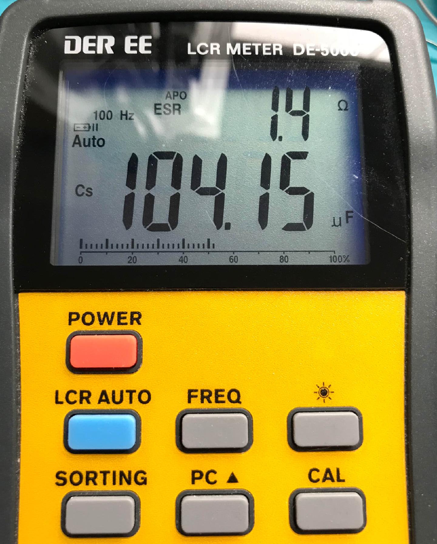 A DER EE DE-5000 LCR meter reading the original decoupling capacitor at 104.15 uF with an ESR of 1.4 ohm