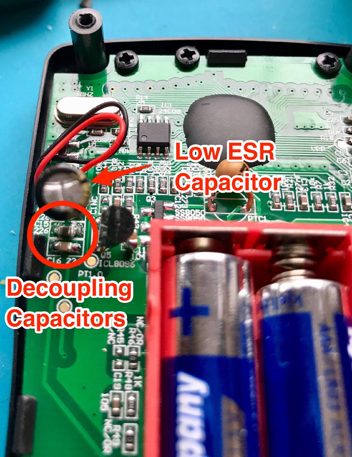The opened AN8008 board with the replacement low-ESR capacitor arrowed and the empty C15 and C16 decoupling pads circled