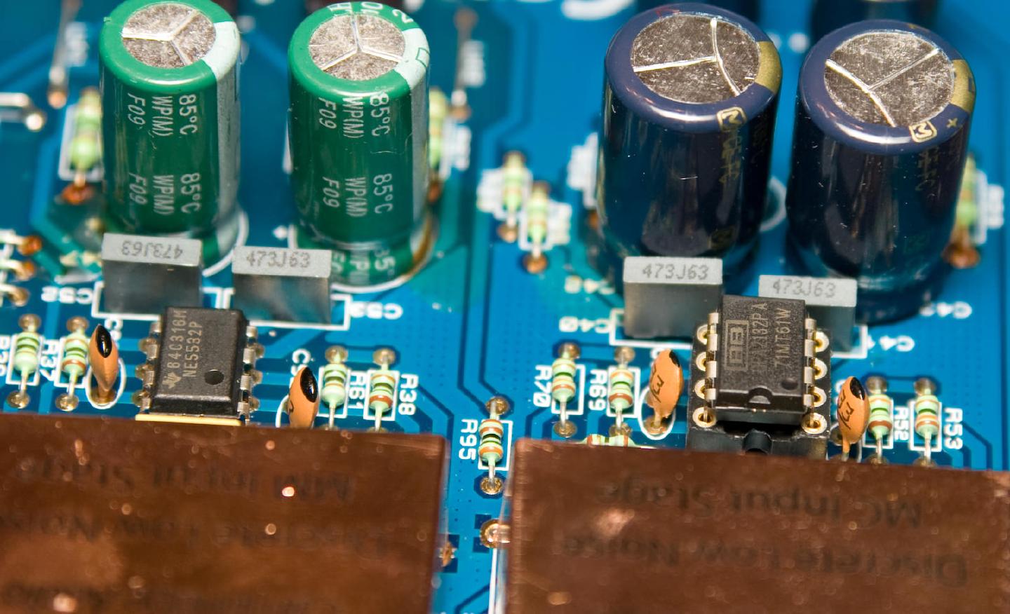 Two op-amps side by side, the original NE5532 on the left and the replacement Burr-Brown OPA2132PA on the right, under green and blue electrolytics