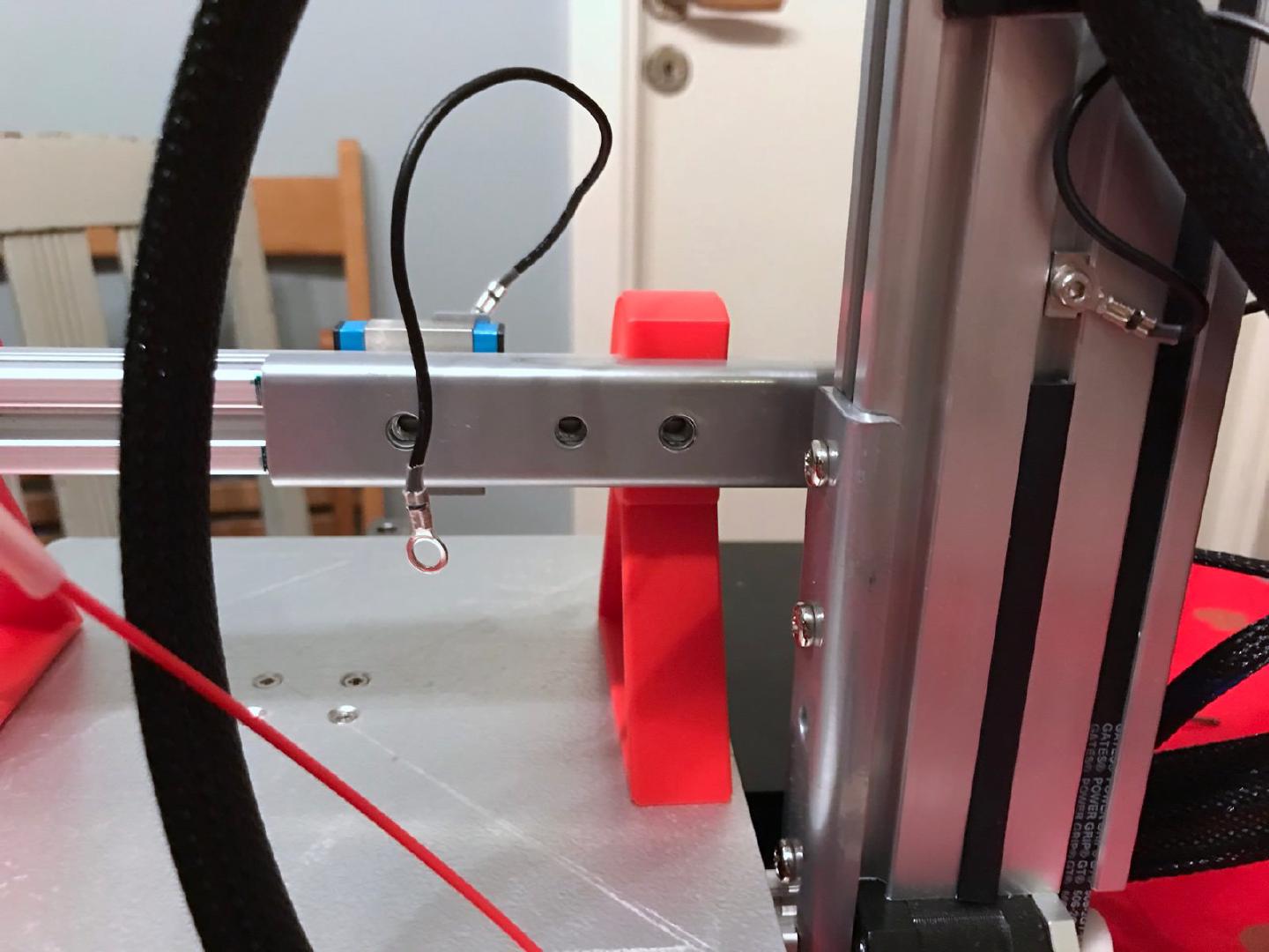 The three screws holding the Y-axis rail to the Z-axis tower, reached from the back of the printer