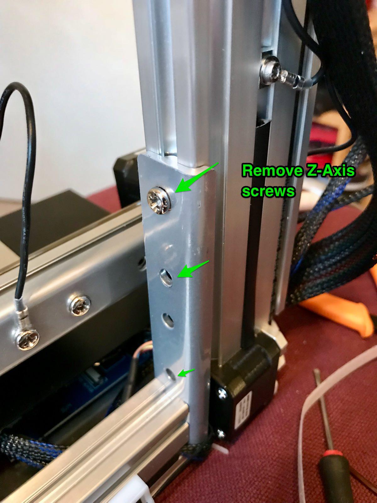 The Z-axis mounting plate with green arrows on the three screws that hold it to the tower
