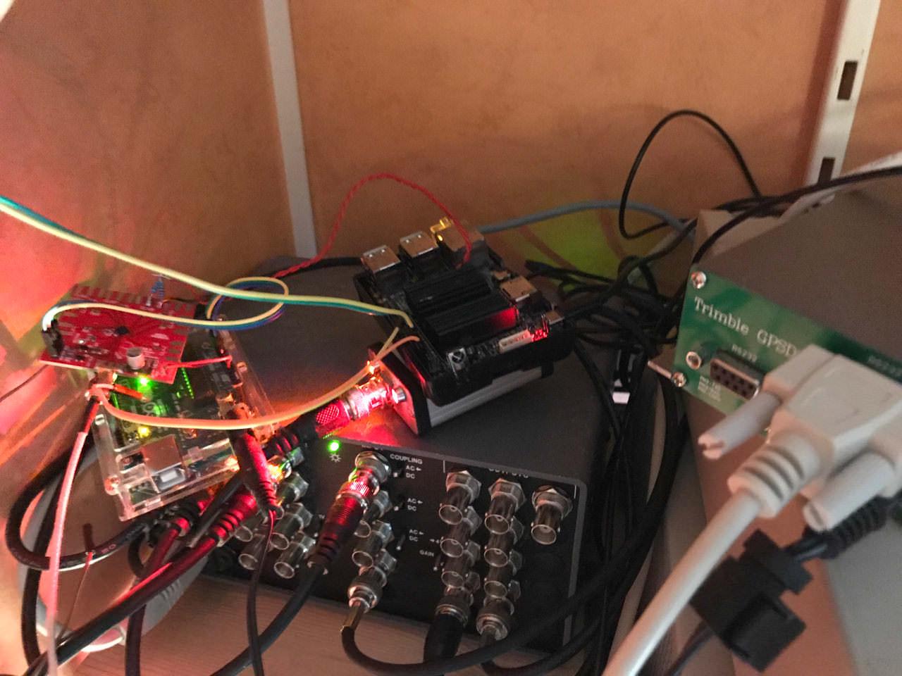 The assembled server on a shelf: the Odroid C2 and SI5351C breakout wired together, beside a distribution amplifier and the Trimble GPSDO