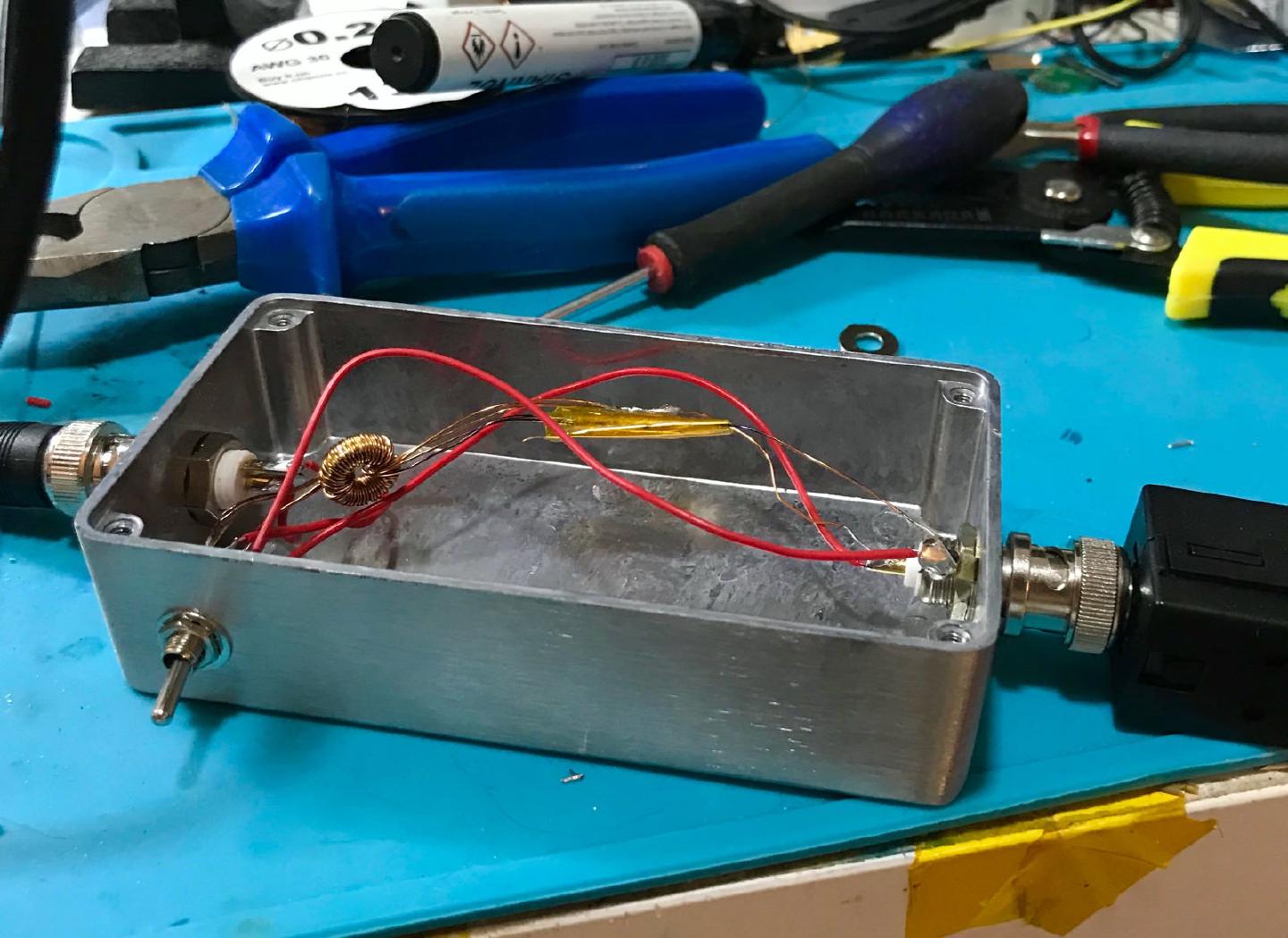 Inside the choke box, a toroid wound with enamelled wire between two BNC sockets, with a toggle switch to bypass it