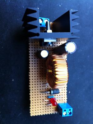 Car Power Supply Raspberry Pi A switching regulator built on stripboard, with a large toroidal inductor, two heatsinks and screw terminals at each end