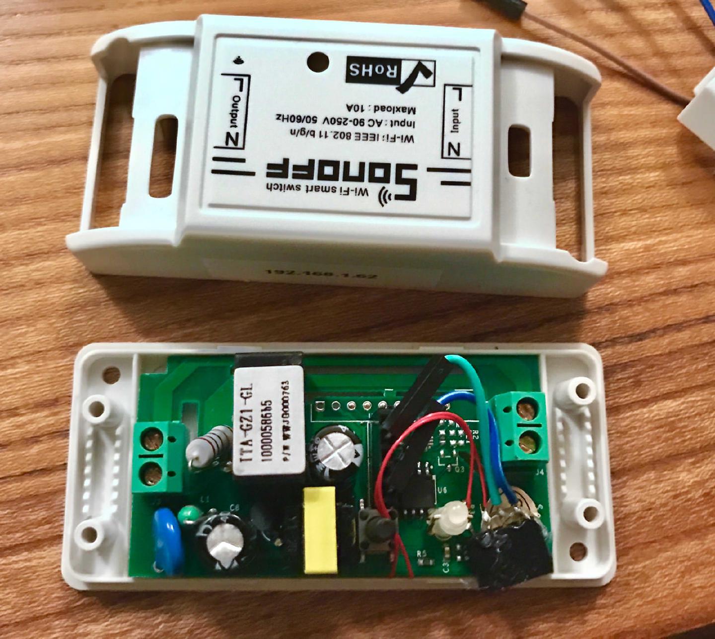 The opened Sonoff enclosure with four coloured I2C wires run from the board out past the edge of the case