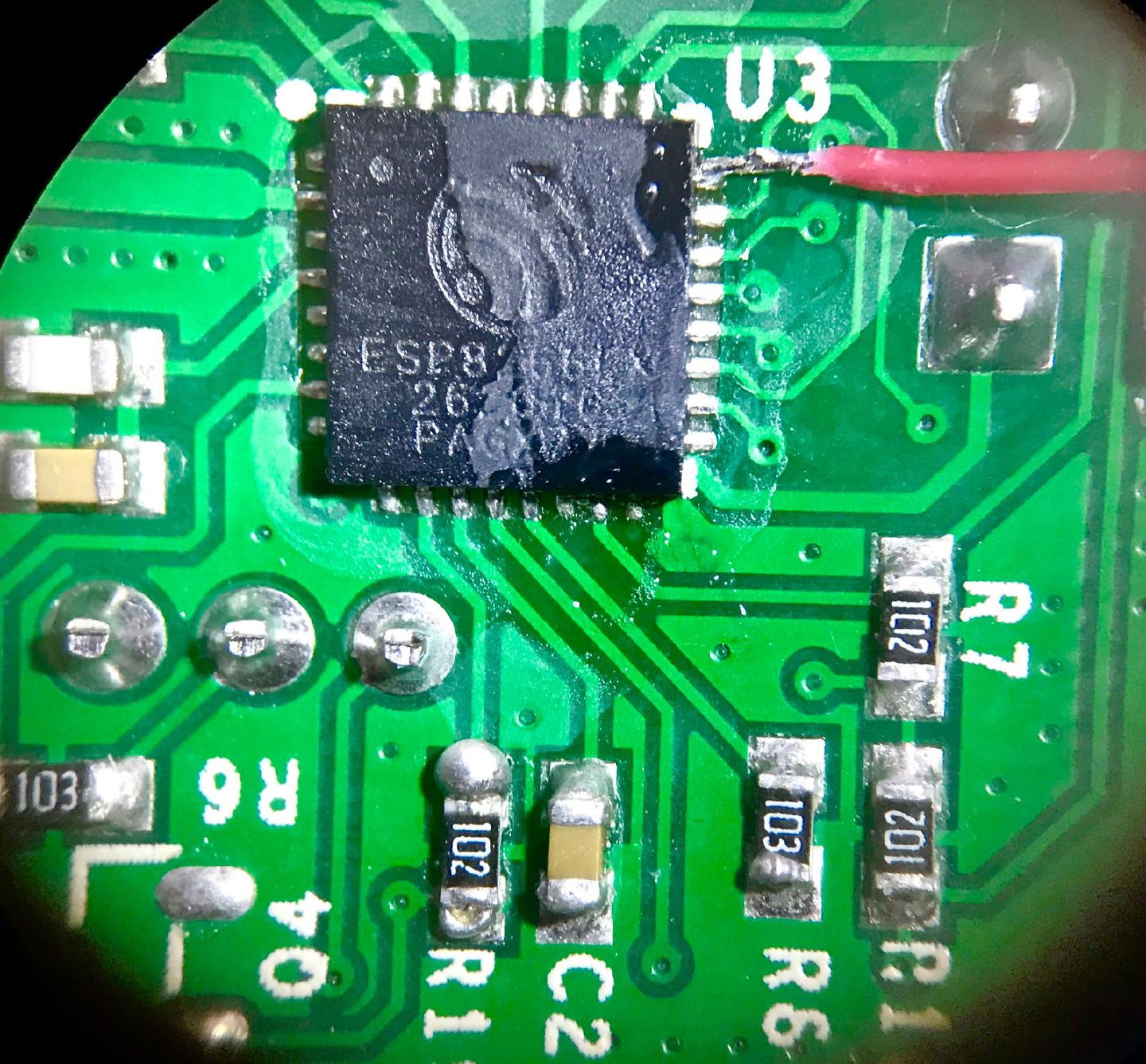 Microscope view of the Sonoff board with a red wire soldered to the GPIO5 pin on the corner of the ESP8266