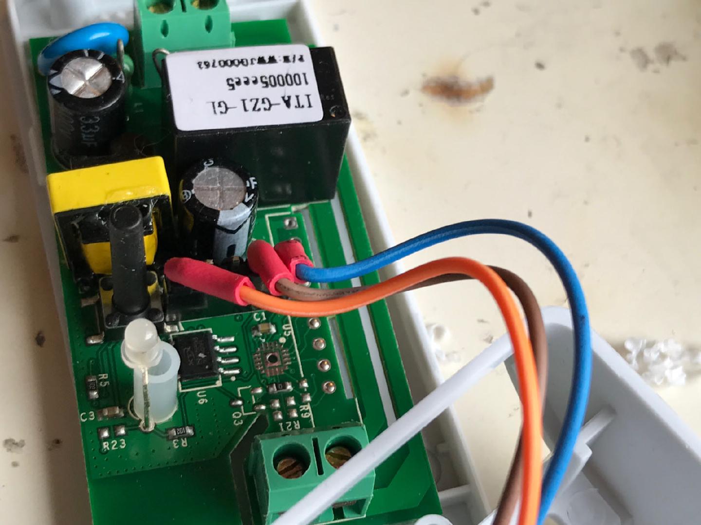 The Sonoff board out of its case, with the I2C wires soldered on and heatshrink over the joints where they pick up power